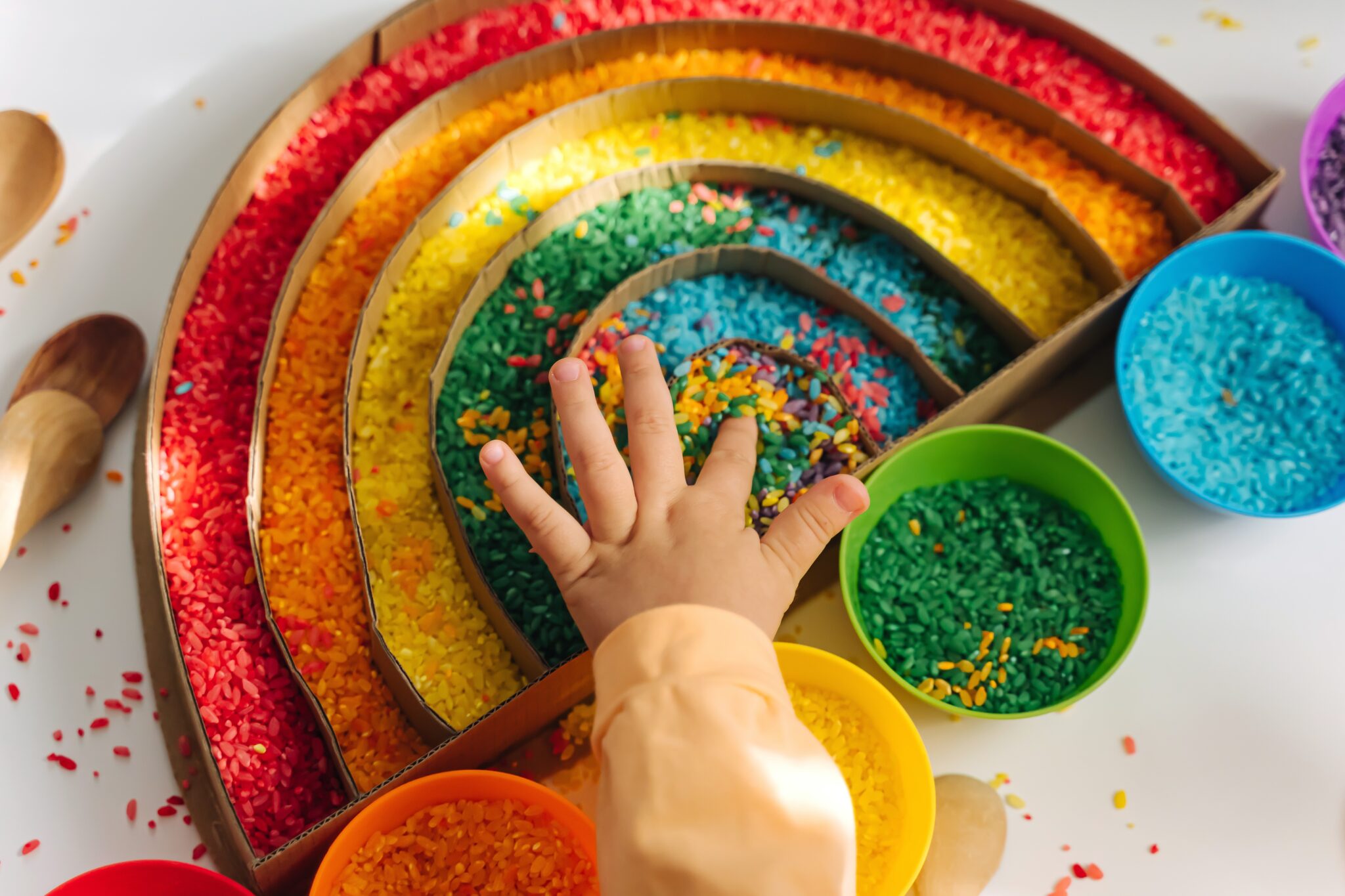 child,hands,playing,colored,rice,and,make,rainbow.,child,filled
